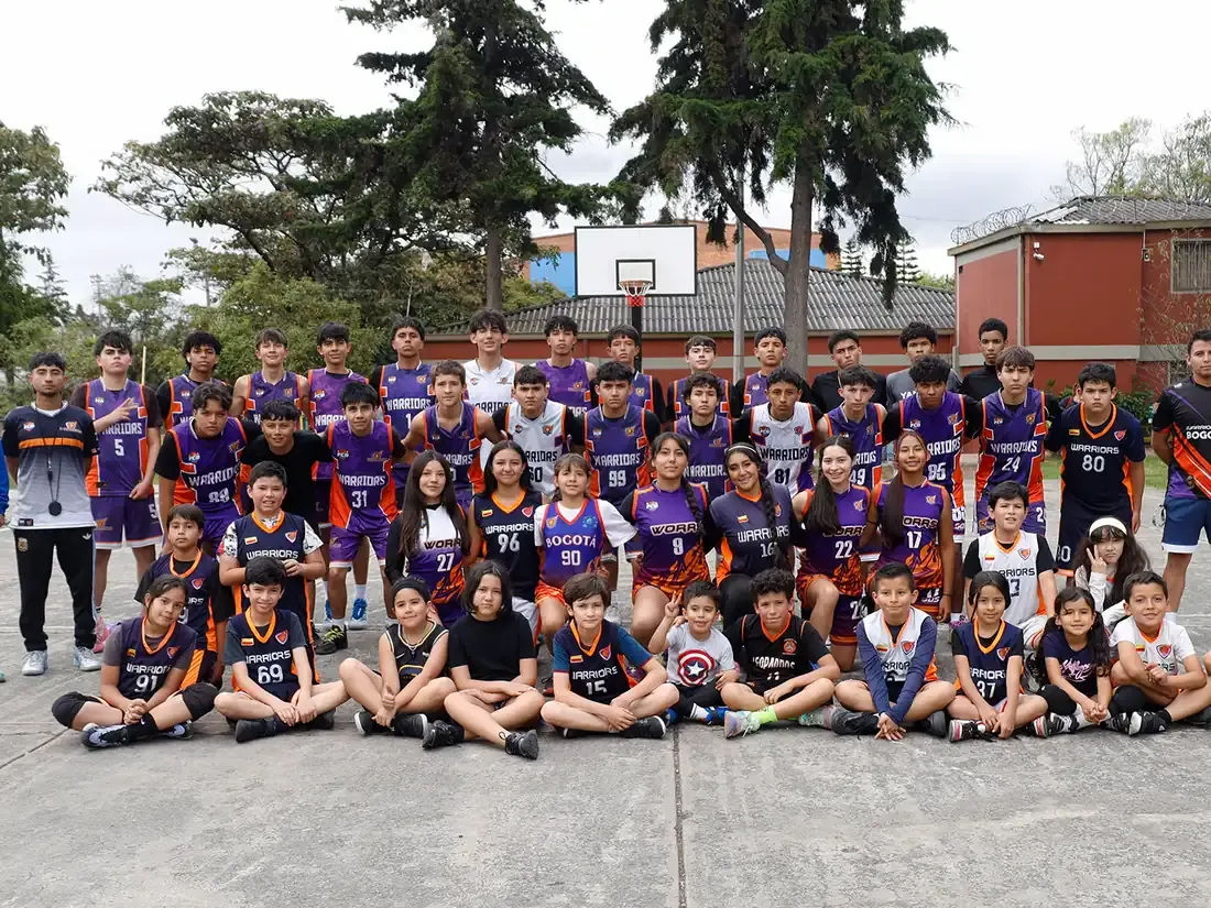 Grupo completo de deportistas y entrenadores de Escuela Warriors en la cancha